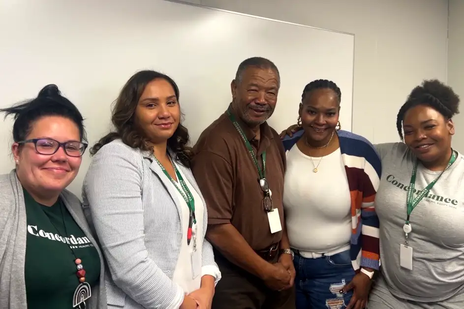 5 people stand in a line and smile for the camera.