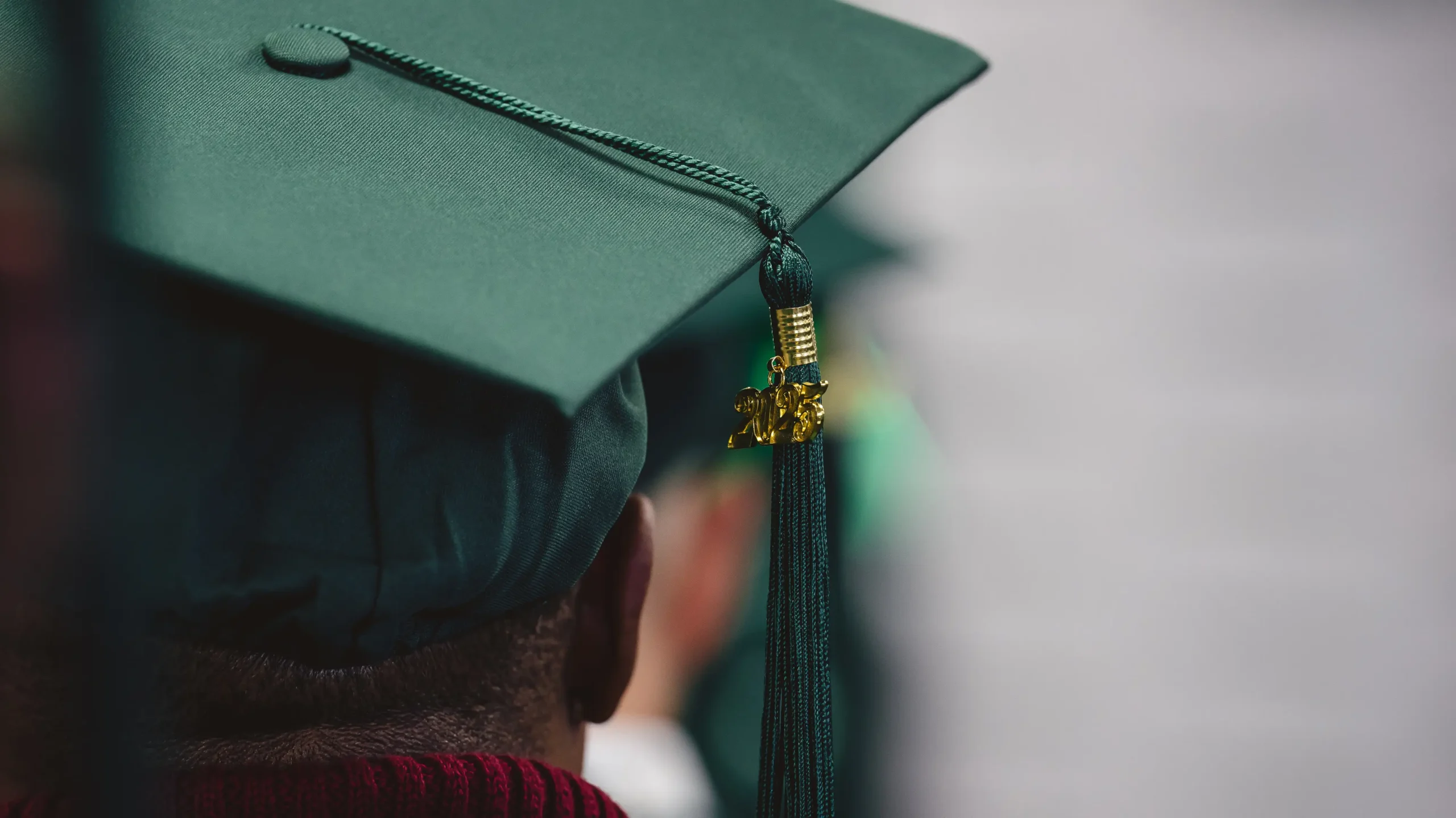 A close up of a green graduation hat with the 2025 tassle