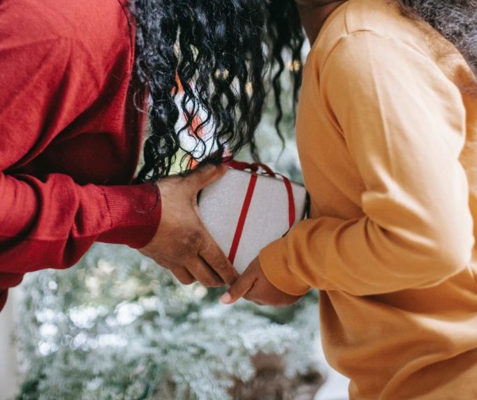Someone handing someone else a wrapped present.