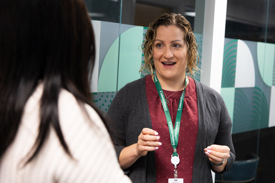Two women speaking, one is facing the camera.