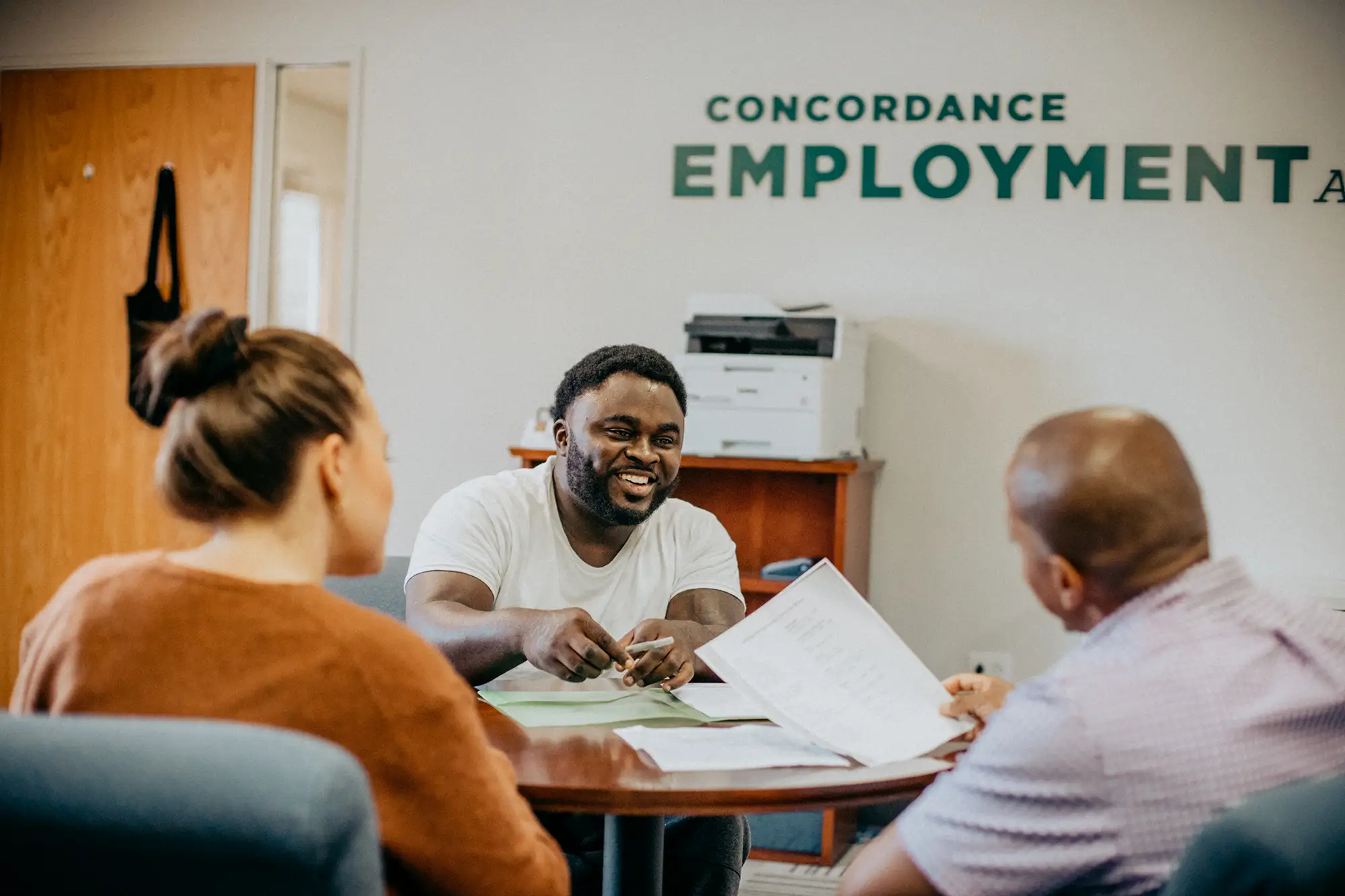 Concordance-table A man discussing paperwork with another man and woman.